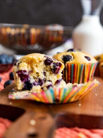 half opened blueberry muffins showing the texture and placed on the wooden plank.