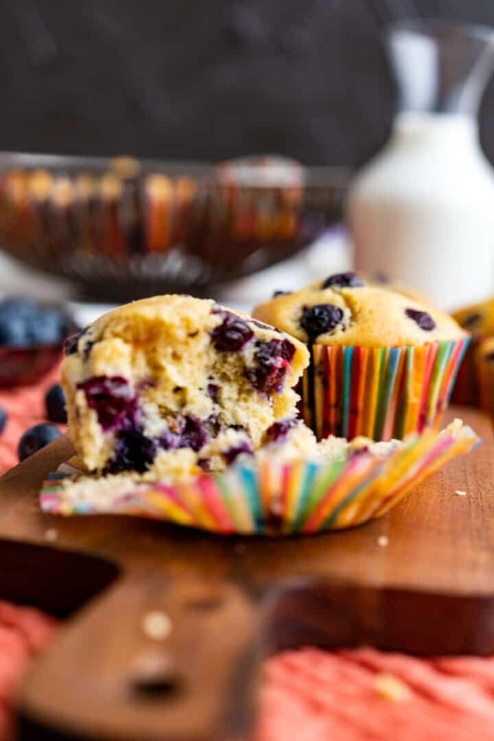 half opened blueberry muffins showing the texture and placed on the wooden plank.