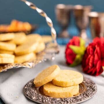 three cookies on a small cute silver plate.