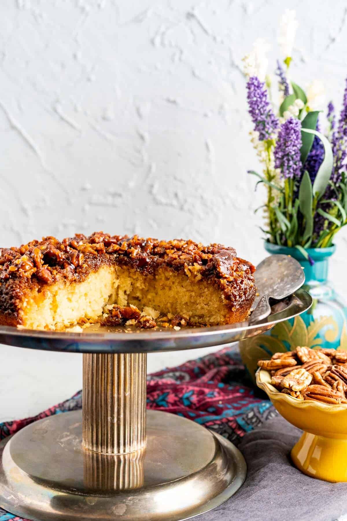 close up of the pecan upside down cake with flowers in the backdrop.