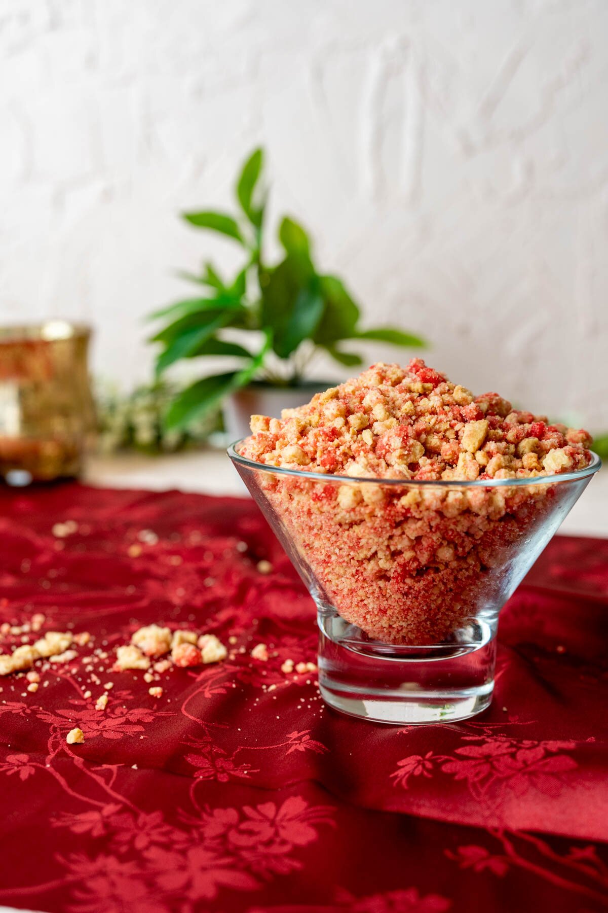 strawberry crunch topping in a transparent bowl on a red table cloth.